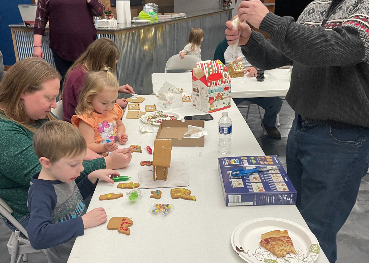 girl's left hand wrap around toddler while reading book during golden hour